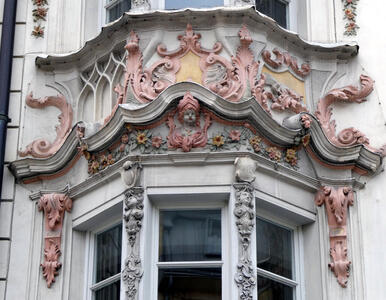 Ornate scrollwork carving, some of which is painted pink.