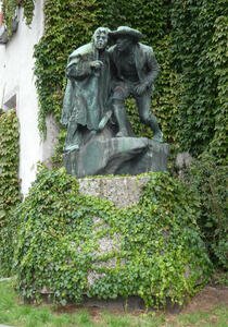 Statue of two men, crouched down and looking forwards.