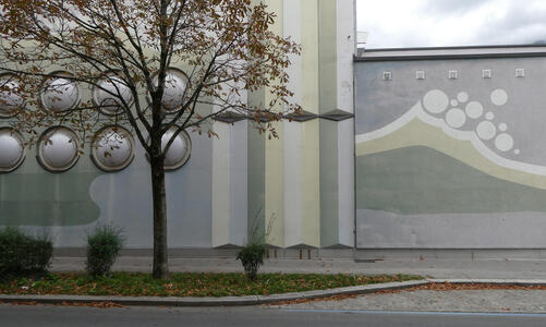 Wall with circular bubbles on left; at right, painting of a wave with foam bubbles