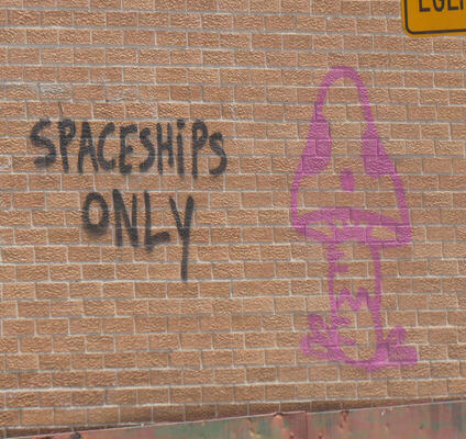 Spaceships only painted on brick wall next to cartoon mushroom