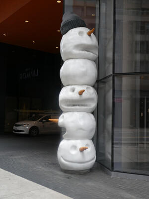 Totem pole made up of heads of snowmen.