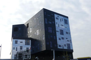 Building tiled with varying sizes of rectangular glass and stone panels.