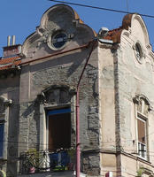 Building with new surface crumbling away to show older brickwork