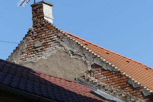 Crumbling covering revealing old red brickwork