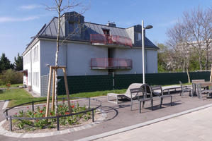 Area with benches and trees in front of house