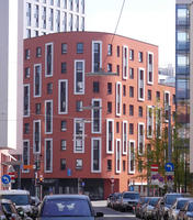 Brown buildng with curved front and skinny rectangular windows framed in white